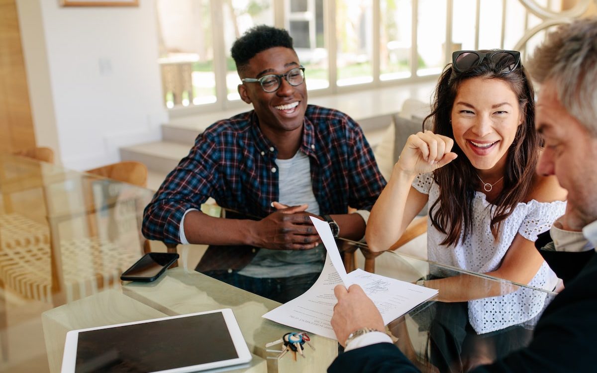 a happy couple reviewing documents with agent