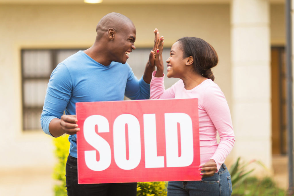 couple with a sold sign