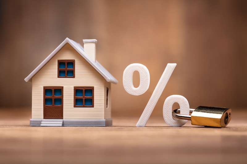 House Model Near Percentage Sign With Keypad Lock Over Wooden Desk