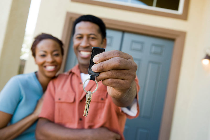 Couple showing keys to new home.