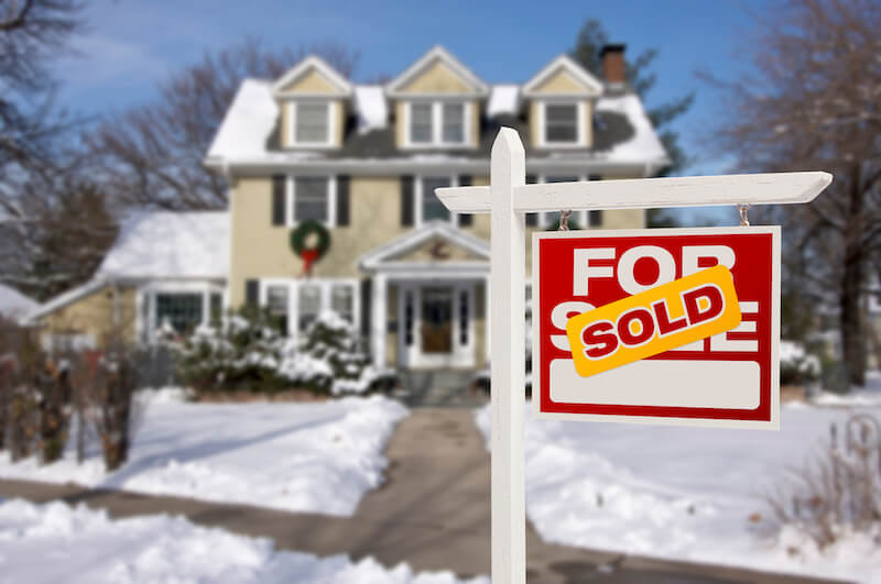 House in winter with a sold sign.