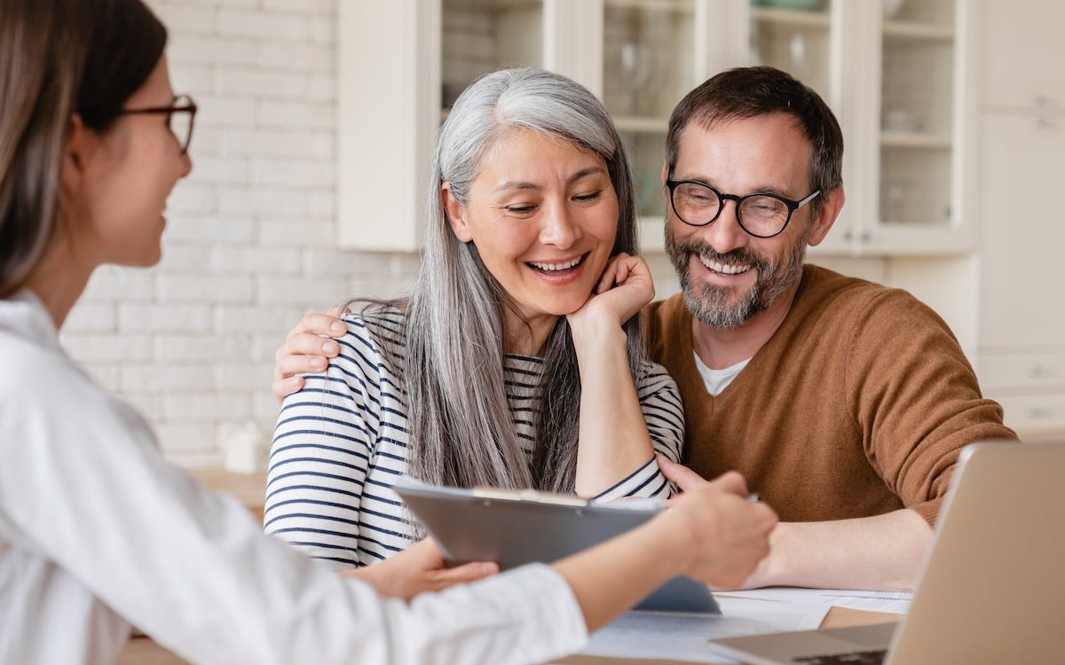 happy couple receiving guidance from real estate agent