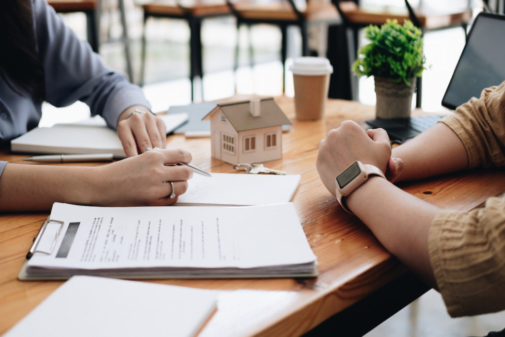 Two people sitting at a table with paperwork in between them