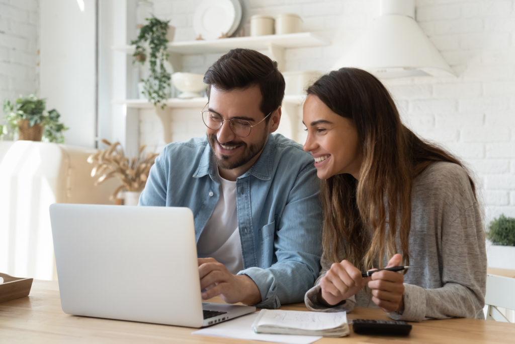 A couple sitting at their computer checking on their finances